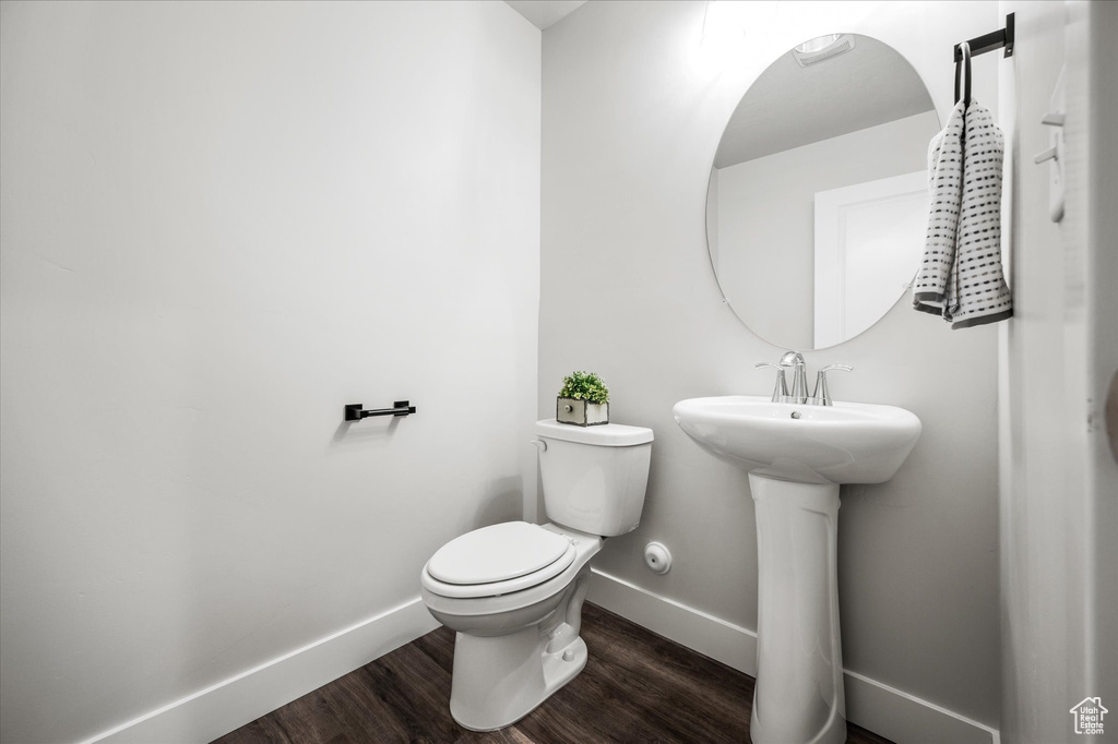 Bathroom with sink, toilet, and wood-type flooring