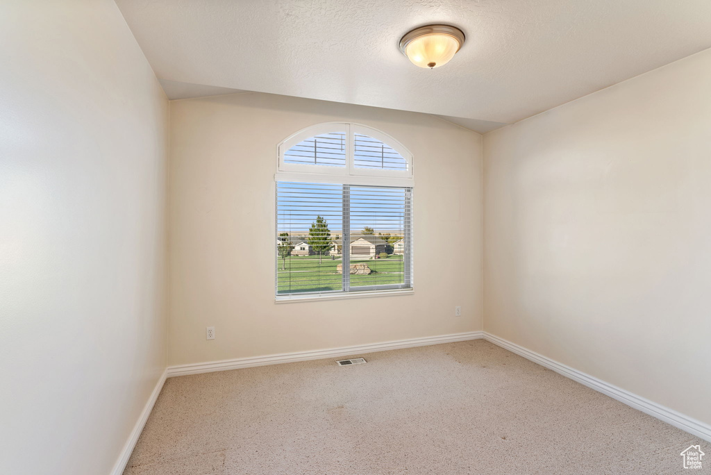 Empty room with a textured ceiling and carpet