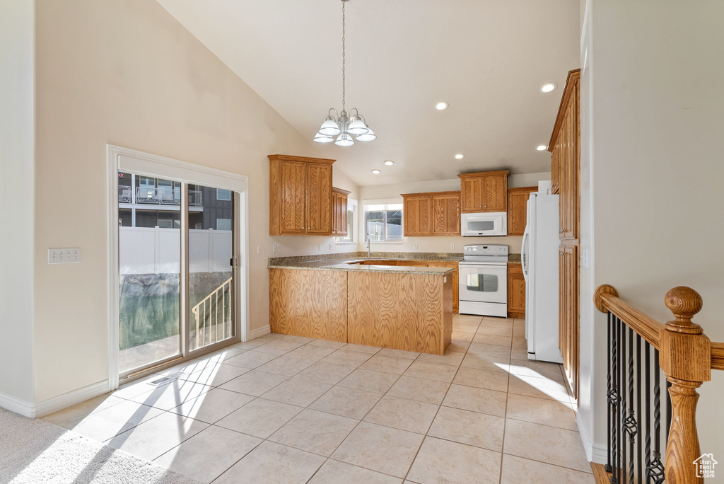 Kitchen featuring an inviting chandelier, white appliances, kitchen peninsula, high vaulted ceiling, and light tile patterned floors