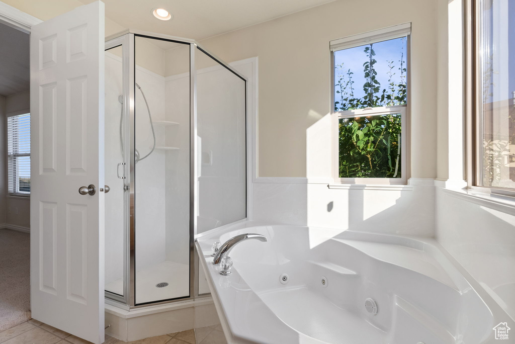 Bathroom featuring a healthy amount of sunlight, tile patterned floors, and shower with separate bathtub