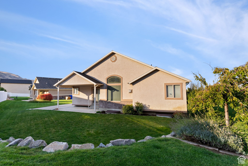 Back of property featuring a yard and a patio area