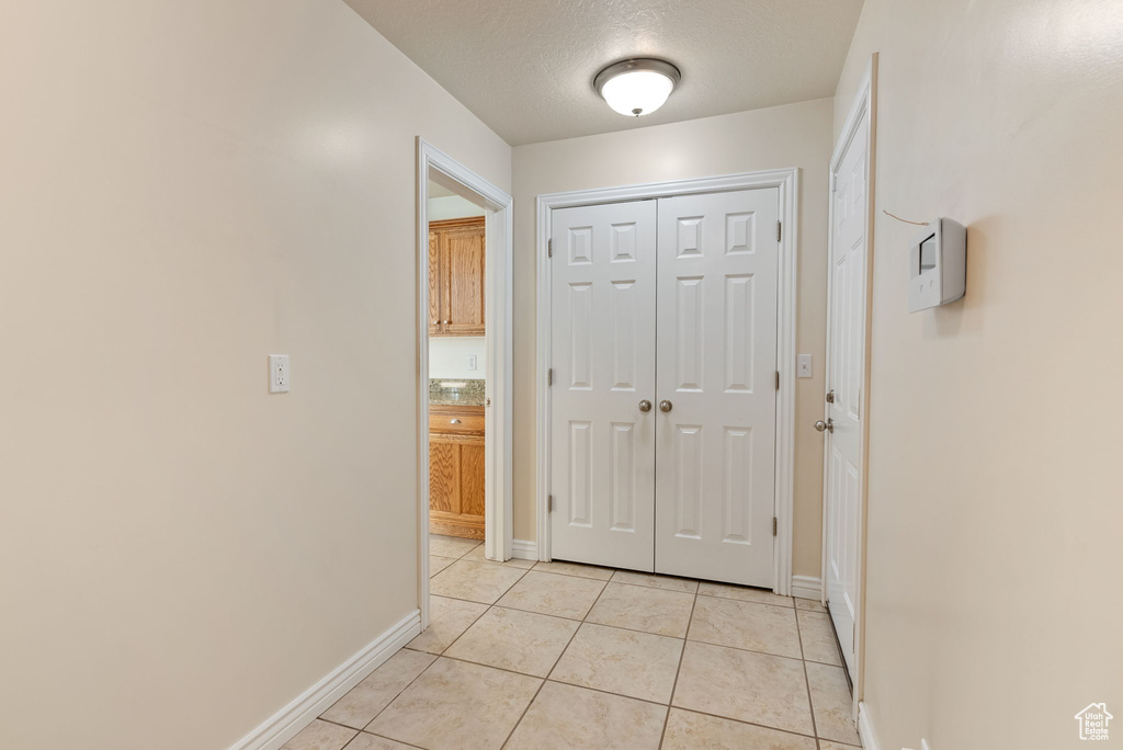 Interior space with light tile patterned flooring and a textured ceiling