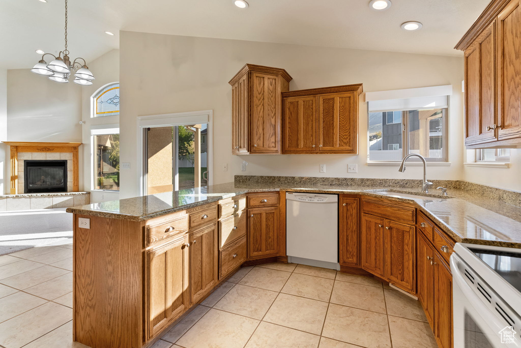 Kitchen featuring white appliances, hanging light fixtures, vaulted ceiling, and an inviting chandelier