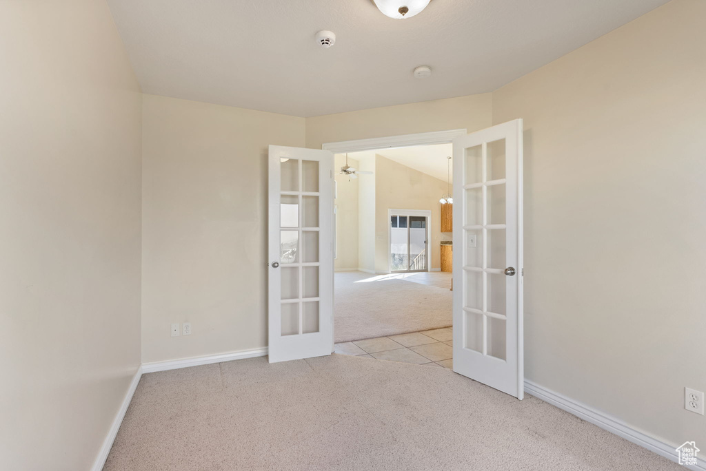 Carpeted spare room featuring french doors