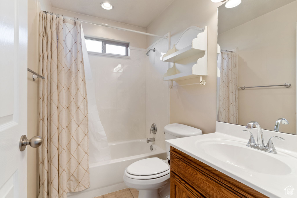 Full bathroom with shower / bathtub combination with curtain, tile patterned floors, vanity, and toilet