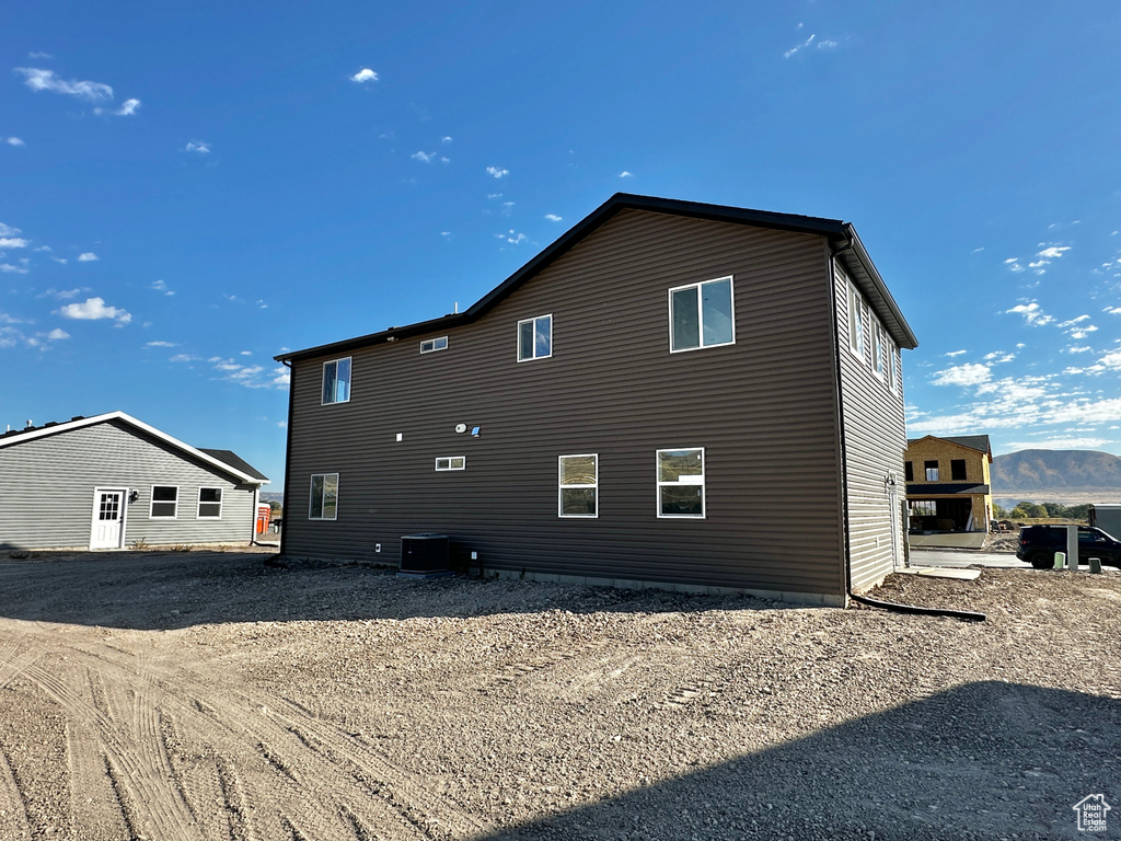 Back of property featuring a mountain view and central AC