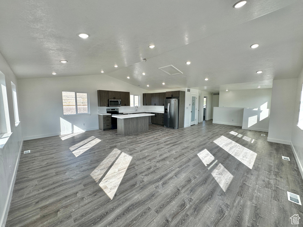 Unfurnished living room featuring lofted ceiling and light hardwood / wood-style flooring