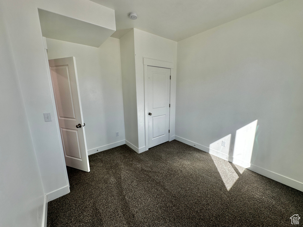 Unfurnished room with dark colored carpet