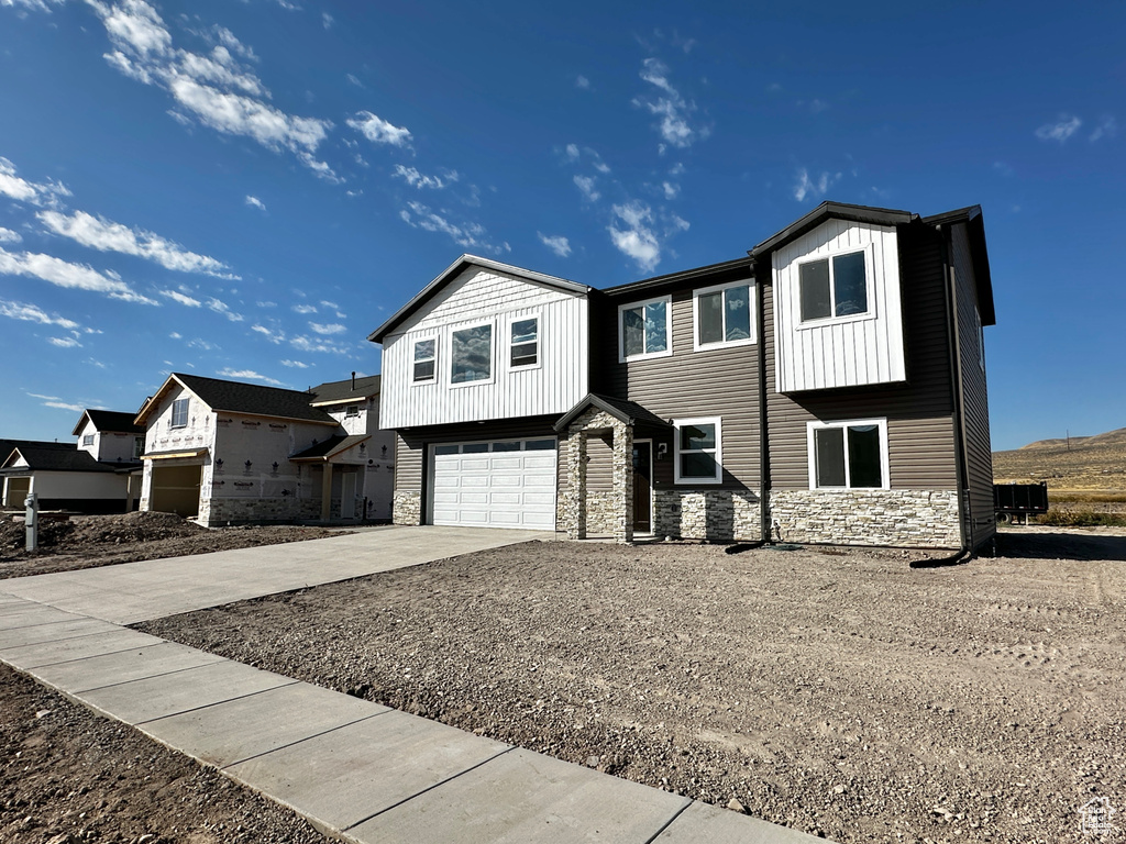 View of front facade featuring central AC unit and a garage