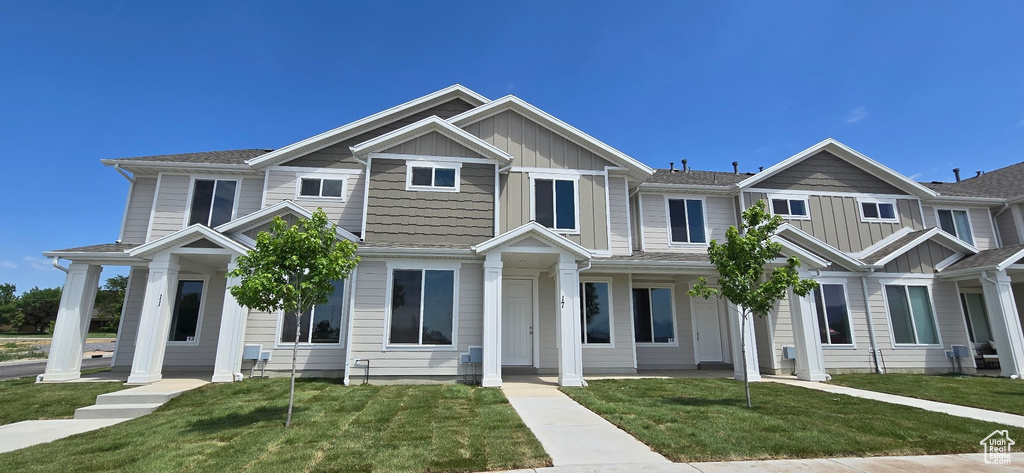 View of front facade featuring board and batten siding and a front yard
