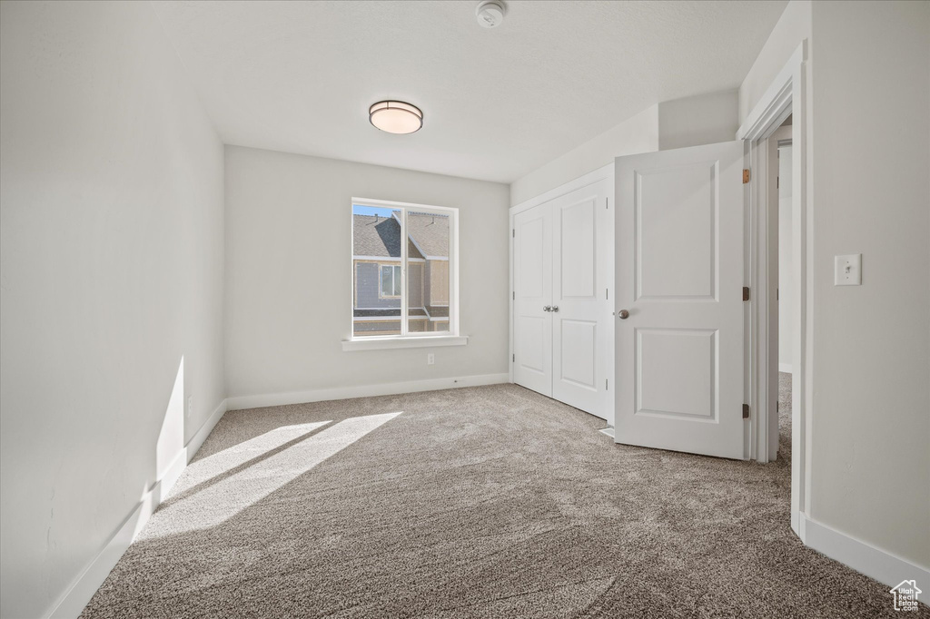 Unfurnished bedroom with a closet and carpet