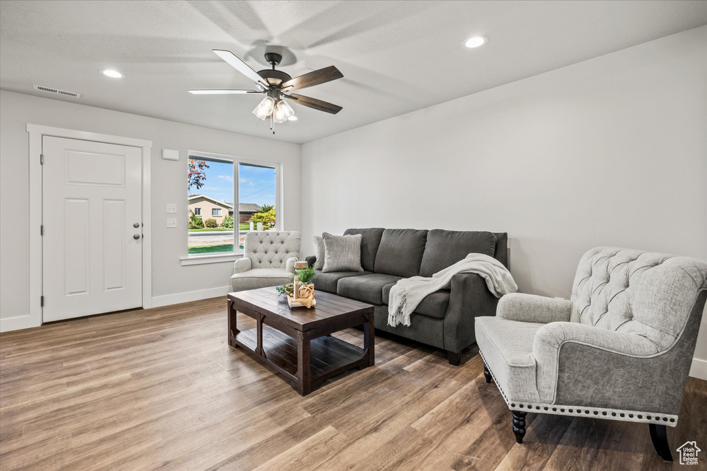 Living room with hardwood / wood-style flooring and ceiling fan