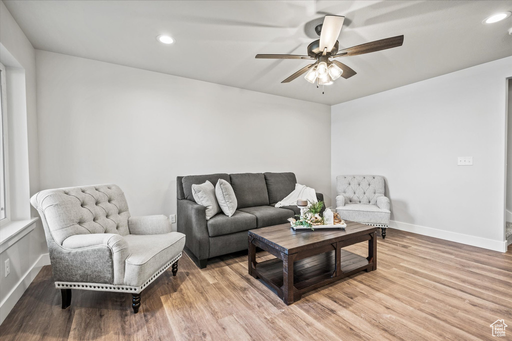 Living room with ceiling fan and light hardwood / wood-style floors