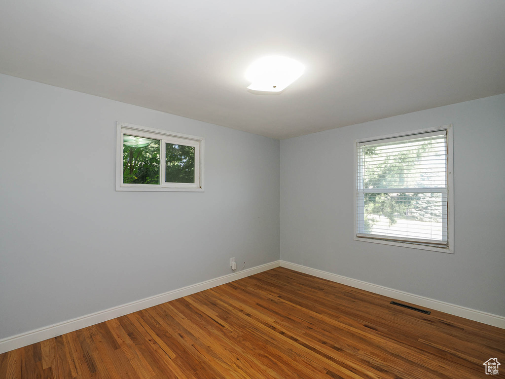 Unfurnished room with wood-type flooring and plenty of natural light