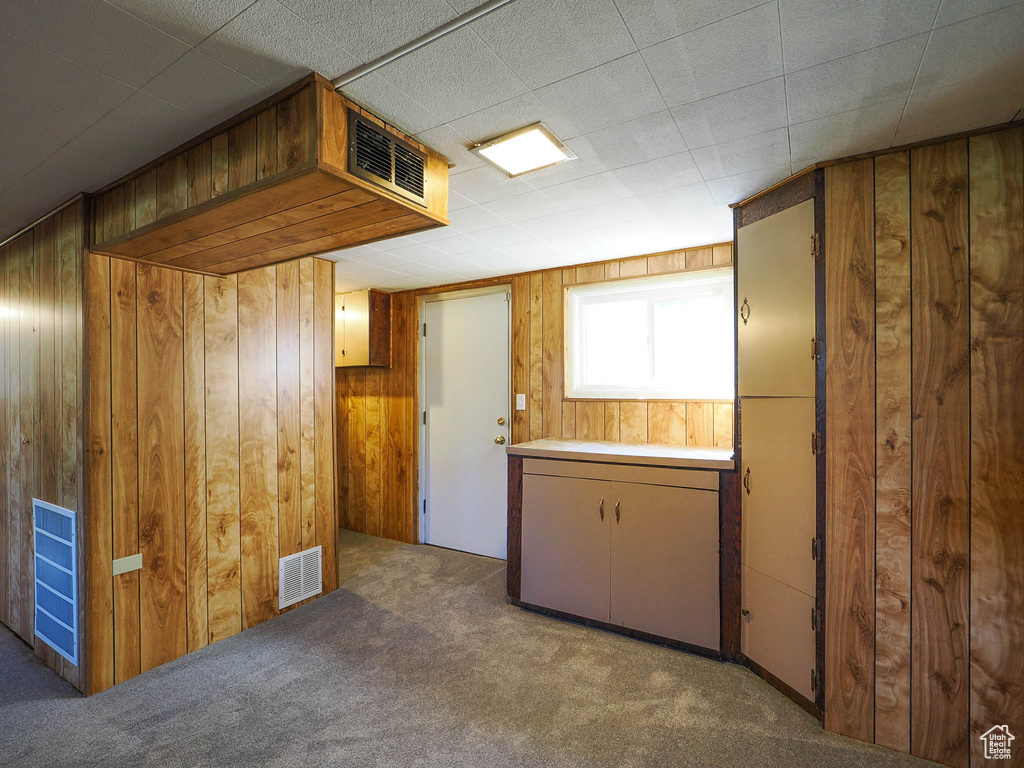 Interior space with light colored carpet and wooden walls