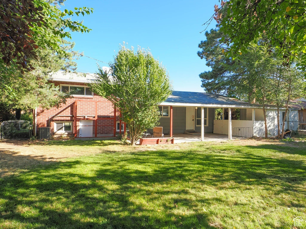 Rear view of property with a yard and a patio