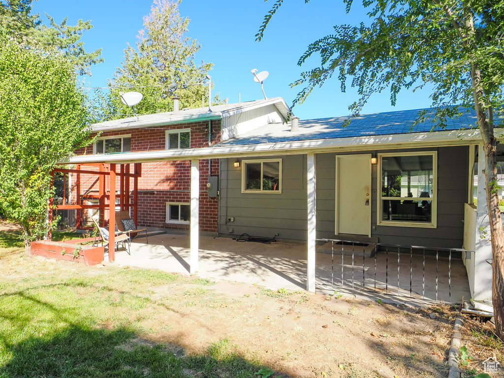 Rear view of house with a lawn and a patio area