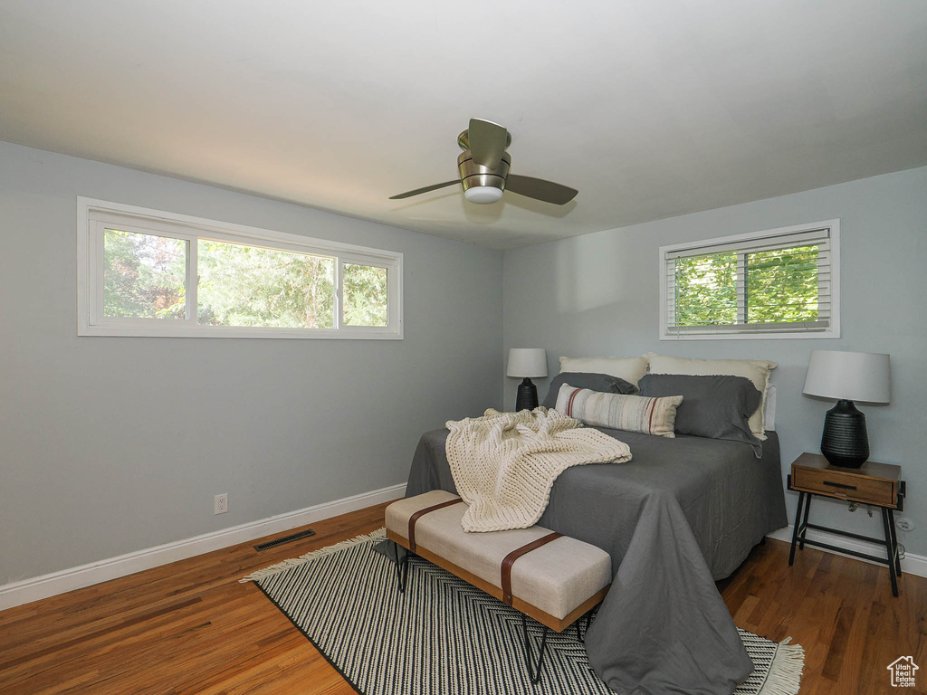 Bedroom featuring ceiling fan, dark wood-type flooring, and multiple windows