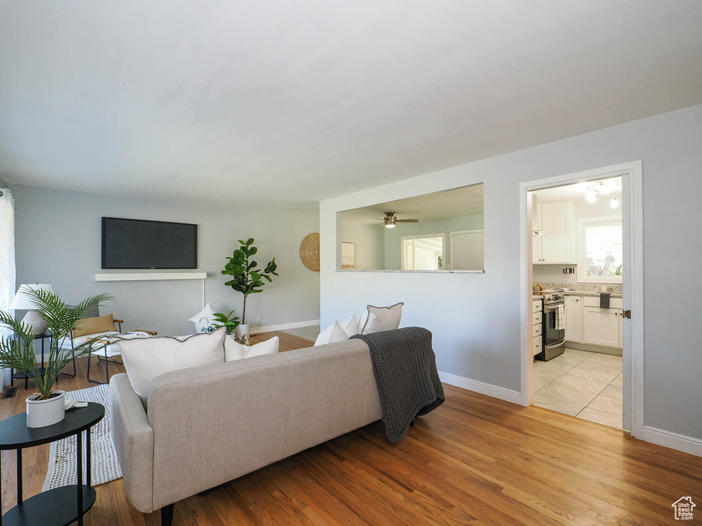 Living room featuring ceiling fan and light hardwood / wood-style floors