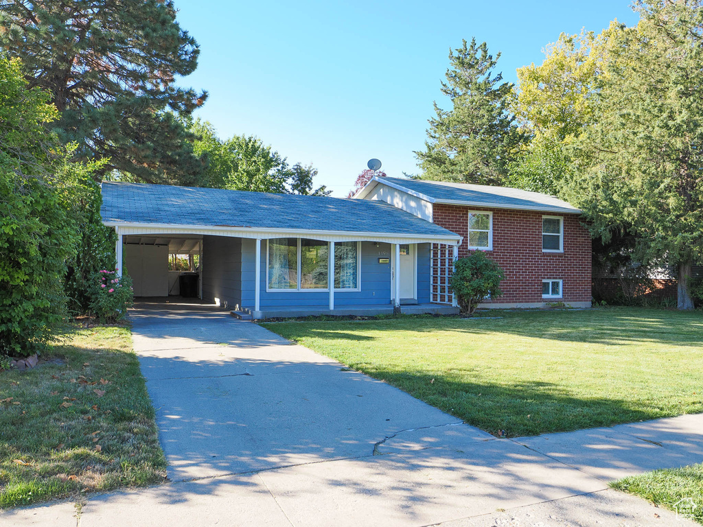 Single story home with a carport and a front yard