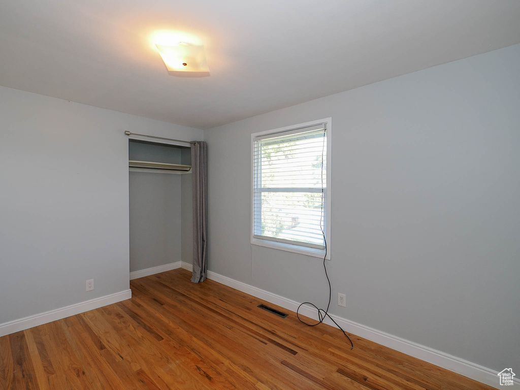 Unfurnished bedroom featuring a closet and hardwood / wood-style flooring