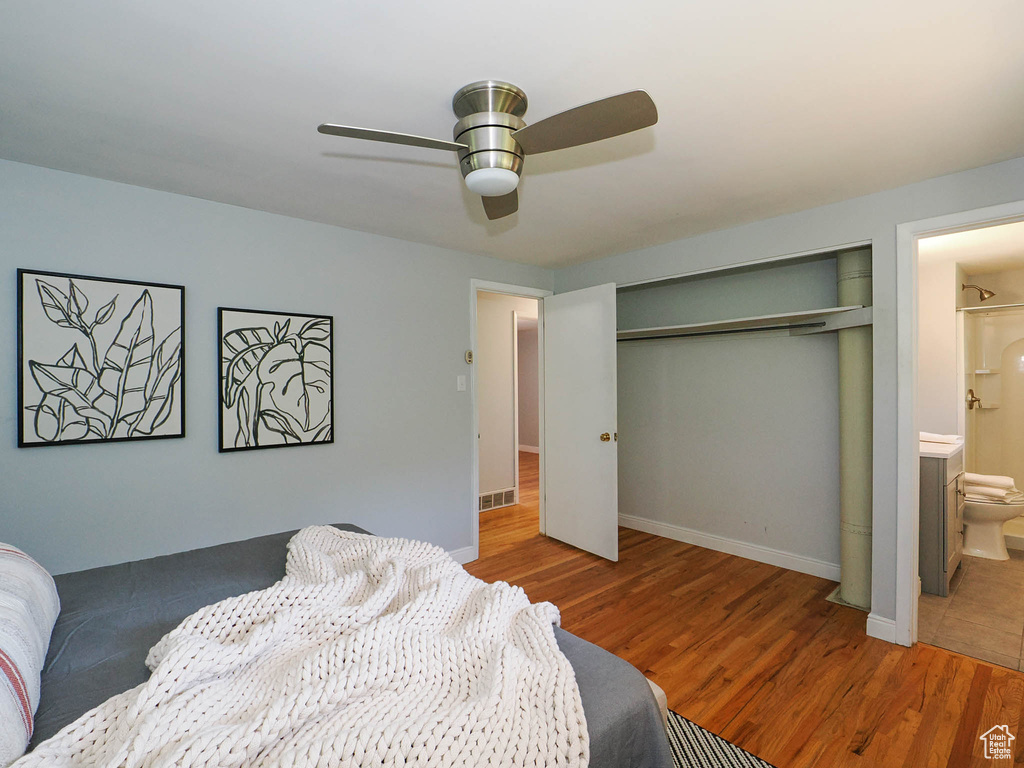 Bedroom featuring ensuite bathroom, ceiling fan, a closet, and hardwood / wood-style floors