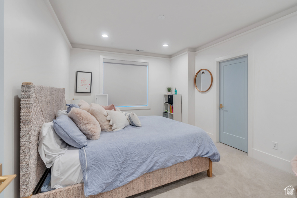 Bedroom featuring light colored carpet and crown molding