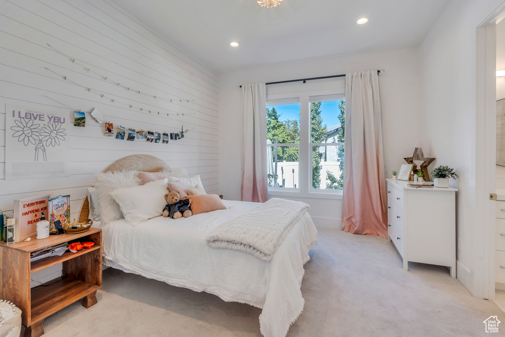 Carpeted bedroom featuring wood walls