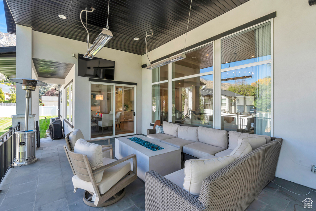 View of patio / terrace with ceiling fan and an outdoor living space with a fire pit