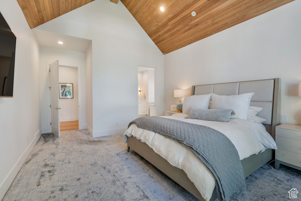 Carpeted bedroom featuring wood ceiling, connected bathroom, and high vaulted ceiling