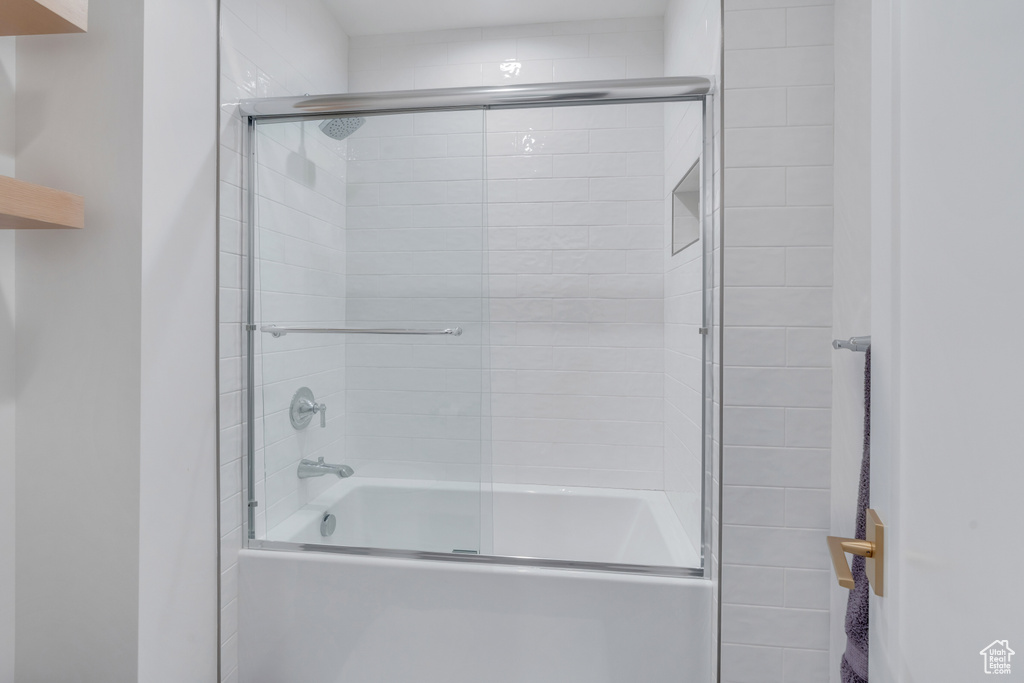 Bathroom featuring shower / bath combination with glass door