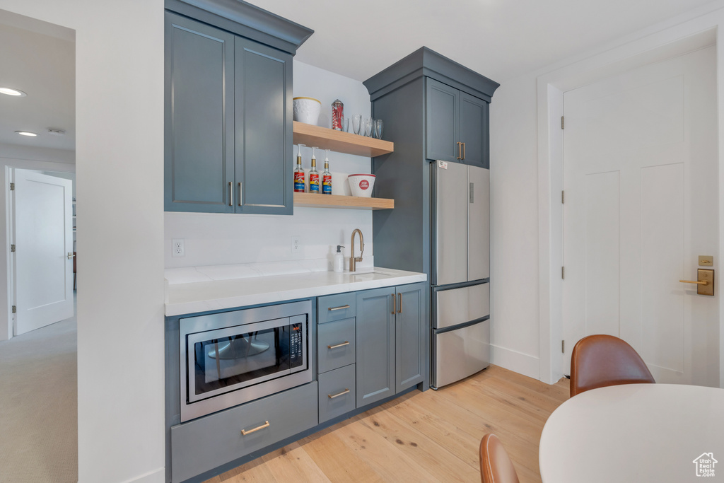 Kitchen featuring appliances with stainless steel finishes, light hardwood / wood-style floors, and sink