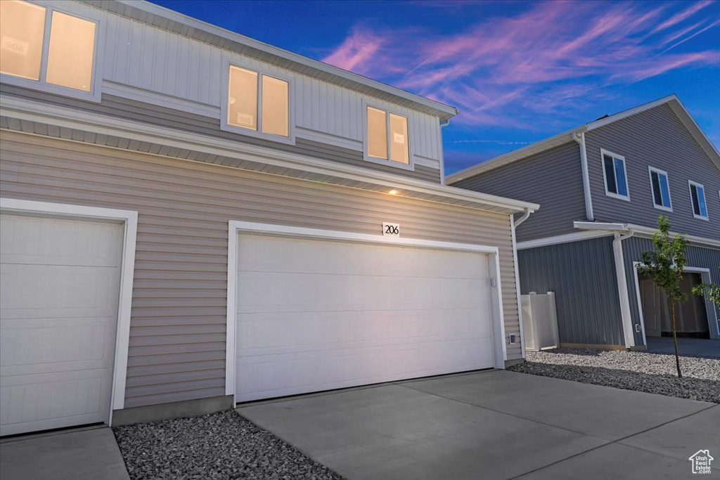 Property exterior at dusk featuring a garage