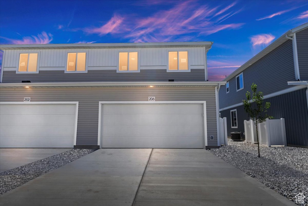 View of front of house featuring central AC unit and a garage