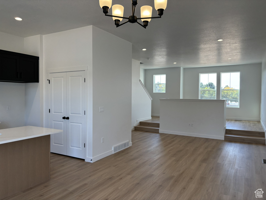 Unfurnished living room featuring a chandelier and wood-type flooring