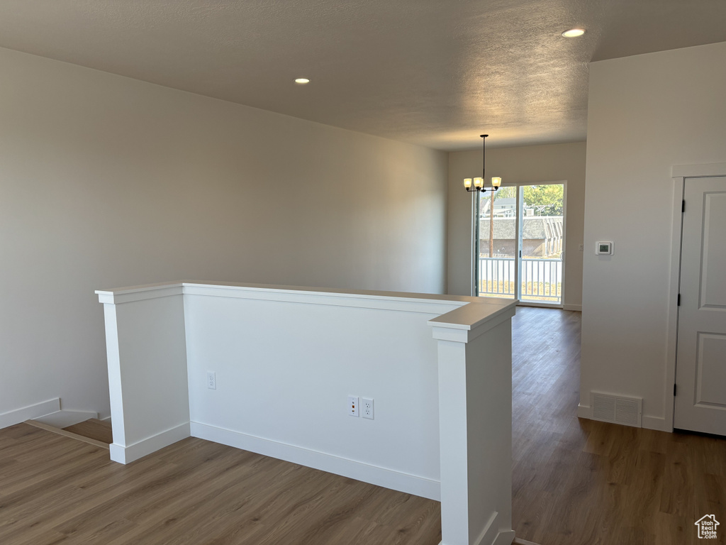 Empty room featuring an inviting chandelier and dark hardwood / wood-style floors