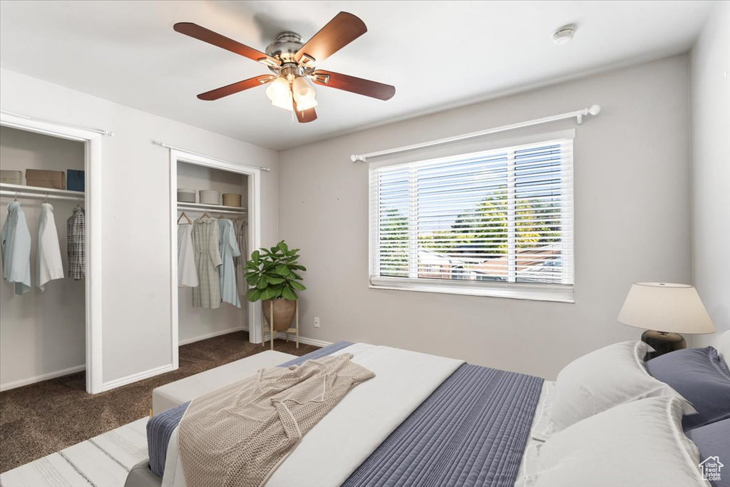 Bedroom featuring ceiling fan and dark carpet