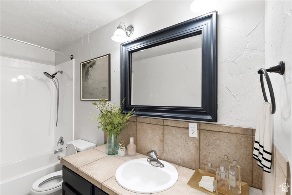 Full bathroom featuring bathing tub / shower combination, tasteful backsplash, vanity, and toilet