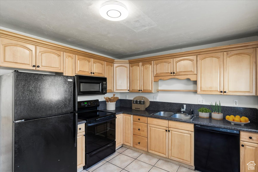 Kitchen featuring light tile patterned floors, black appliances, sink, and light brown cabinets