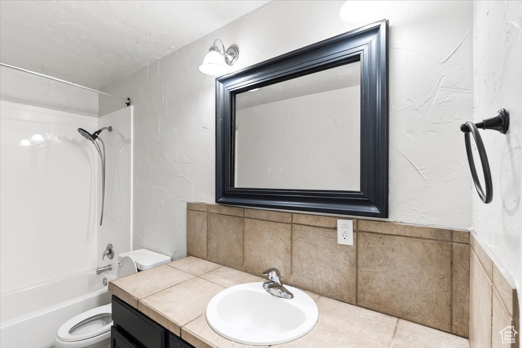 Full bathroom featuring vanity, bathing tub / shower combination, and toilet