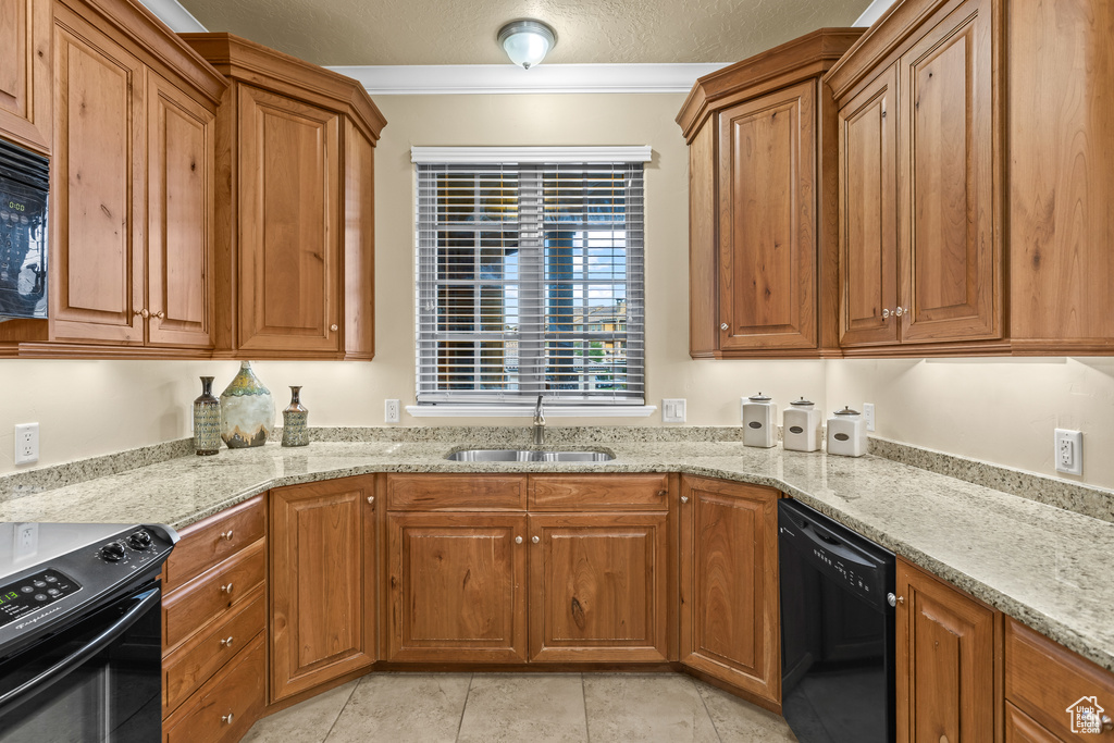 Kitchen with light stone counters, a textured ceiling, crown molding, and black appliances