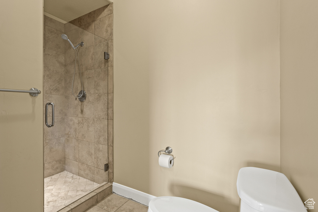 Bathroom with walk in shower, tile patterned floors, and toilet