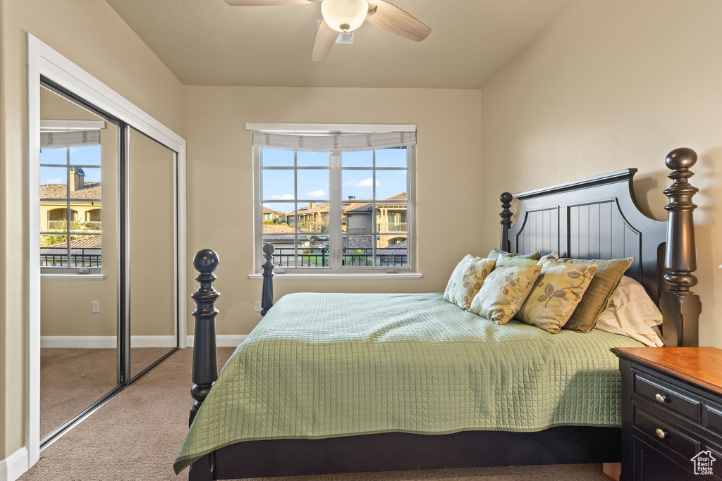 Carpeted bedroom featuring ceiling fan and a closet