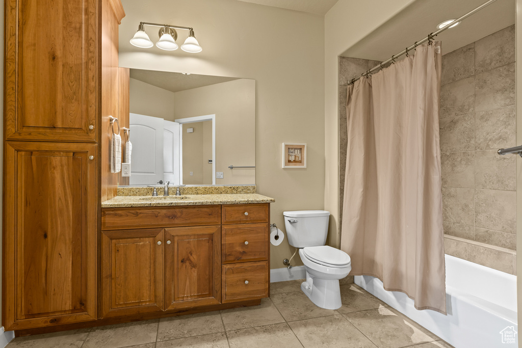 Full bathroom with vanity, tile patterned flooring, toilet, and shower / bath combo