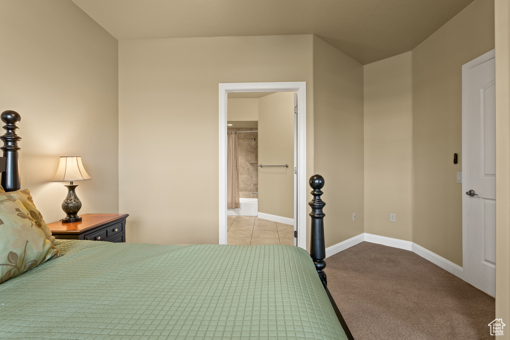 Bedroom featuring light carpet and ensuite bath