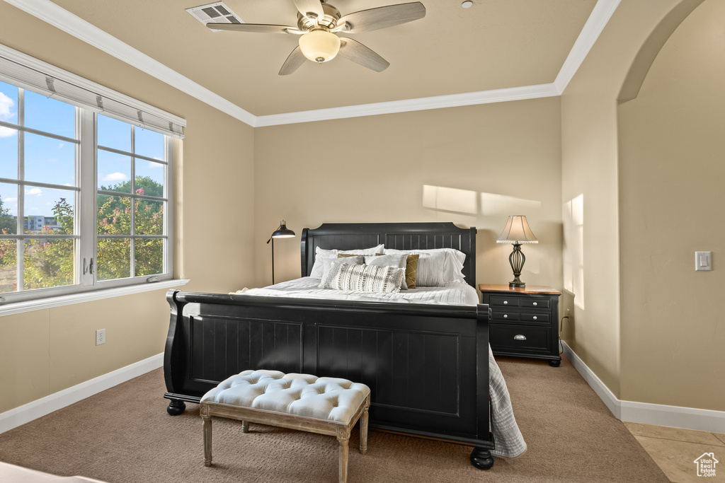 Bedroom with ceiling fan, light tile patterned floors, and ornamental molding