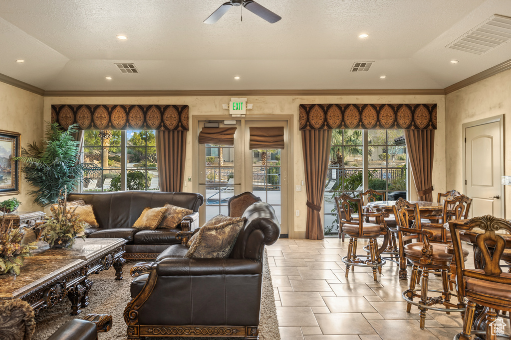 Living room featuring plenty of natural light, crown molding, and ceiling fan