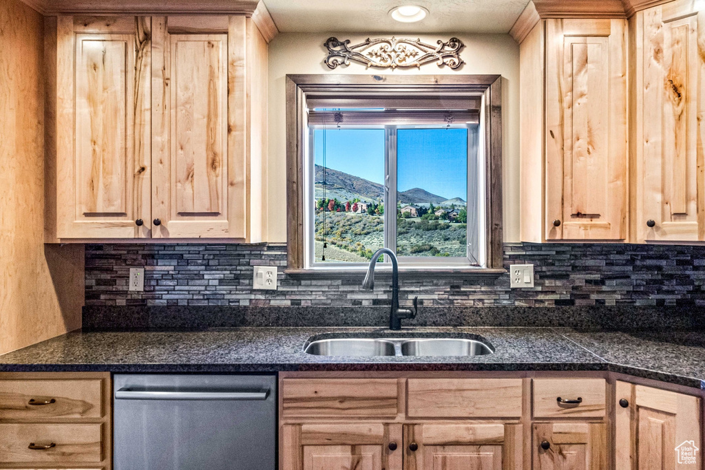 Kitchen with light brown cabinets, stainless steel dishwasher, sink, and a mountain view