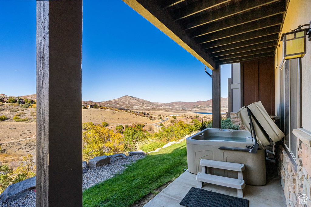 View of patio featuring a hot tub and a mountain view