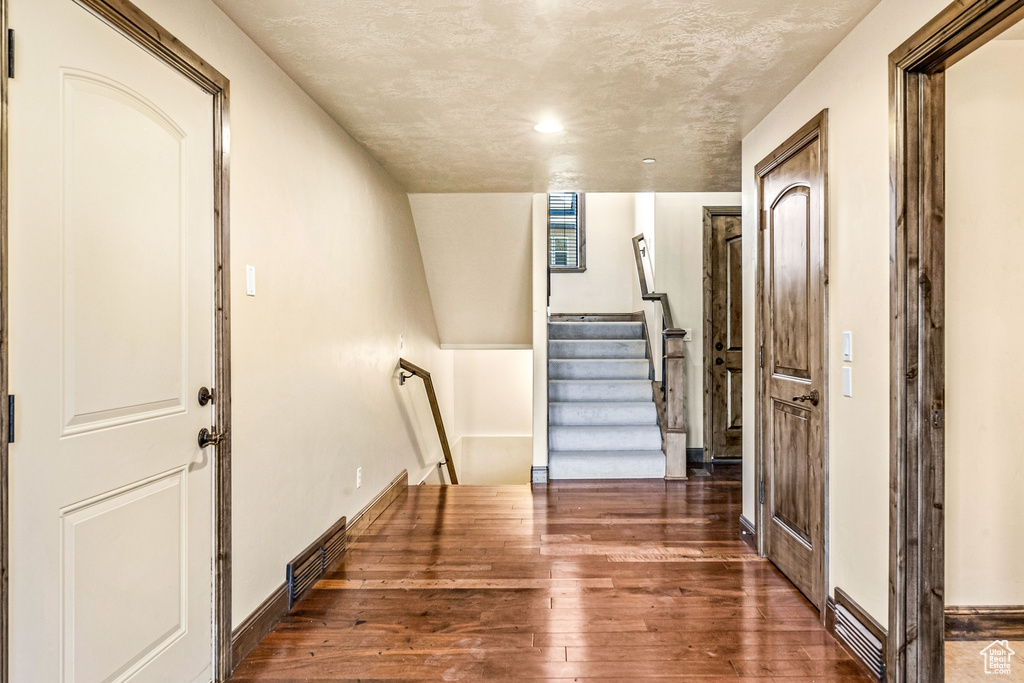 Interior space with a textured ceiling and hardwood / wood-style flooring